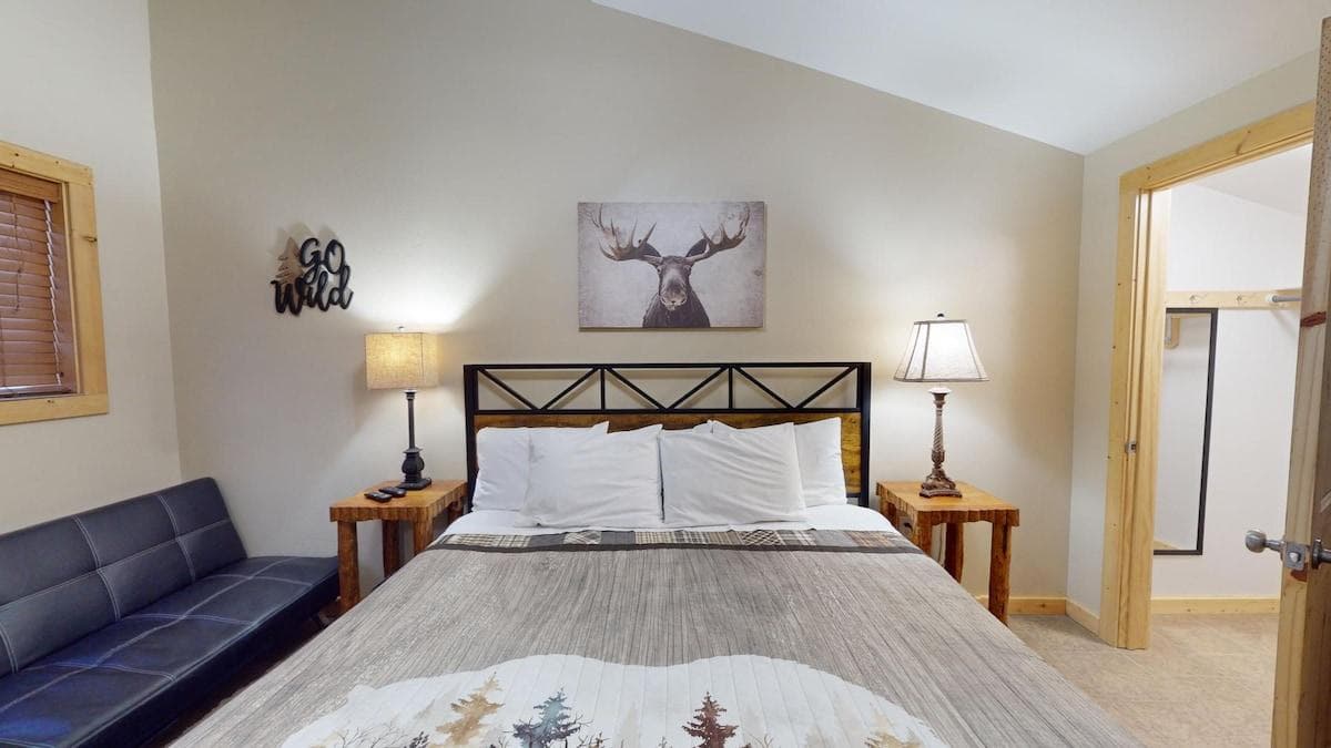 First bedroom with a king size bed, seating, and closet space.