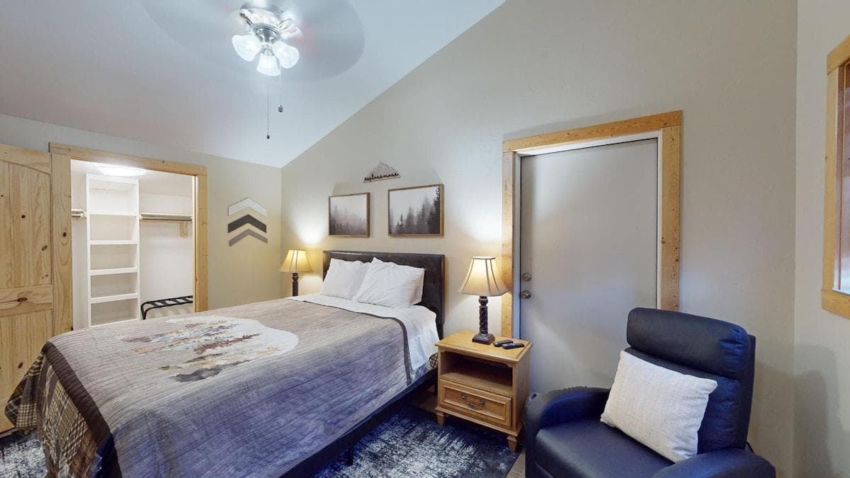 Second bedroom with a queen size bed, seating, and closet.