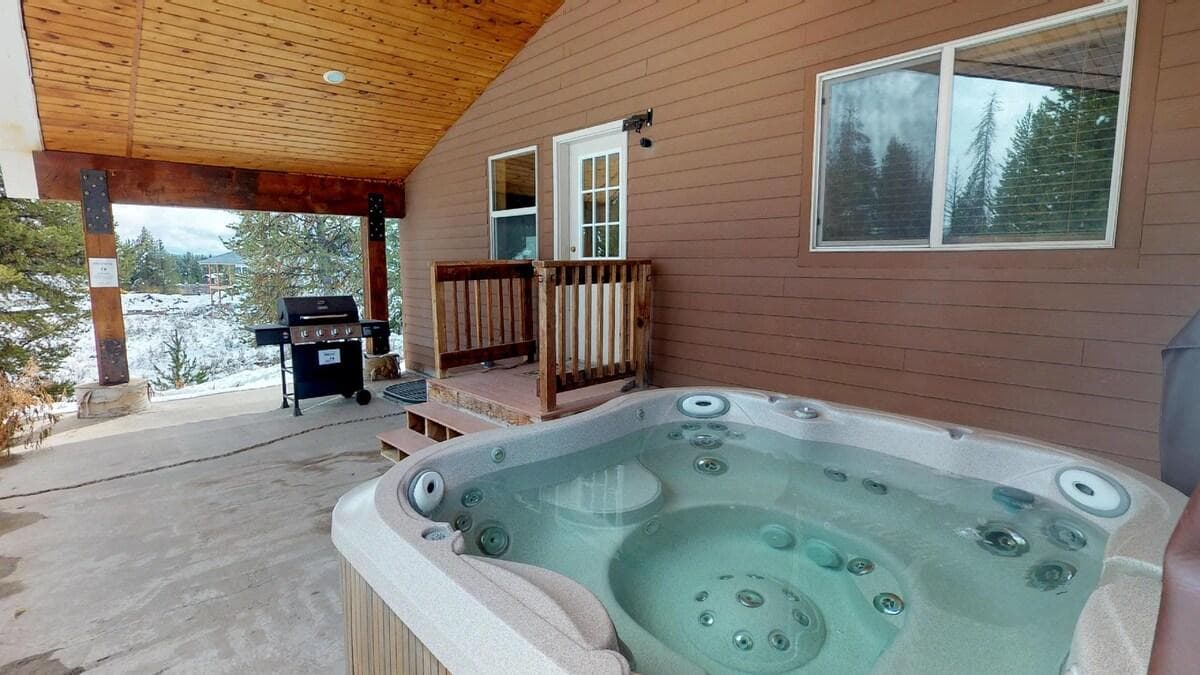 Hot tub and grill are conveniently located outside in the back of the cabin.